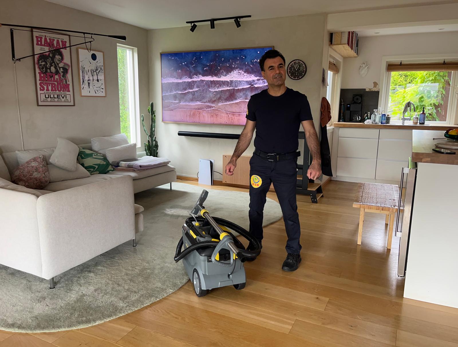 Piroz Vikan med profesjonell tepperensmaskin i en stue